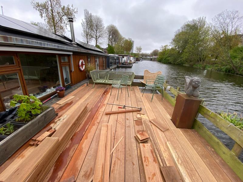 Nieuwe houten vlonder op een woonboot aan de Rotterdamse gracht, net gelegd